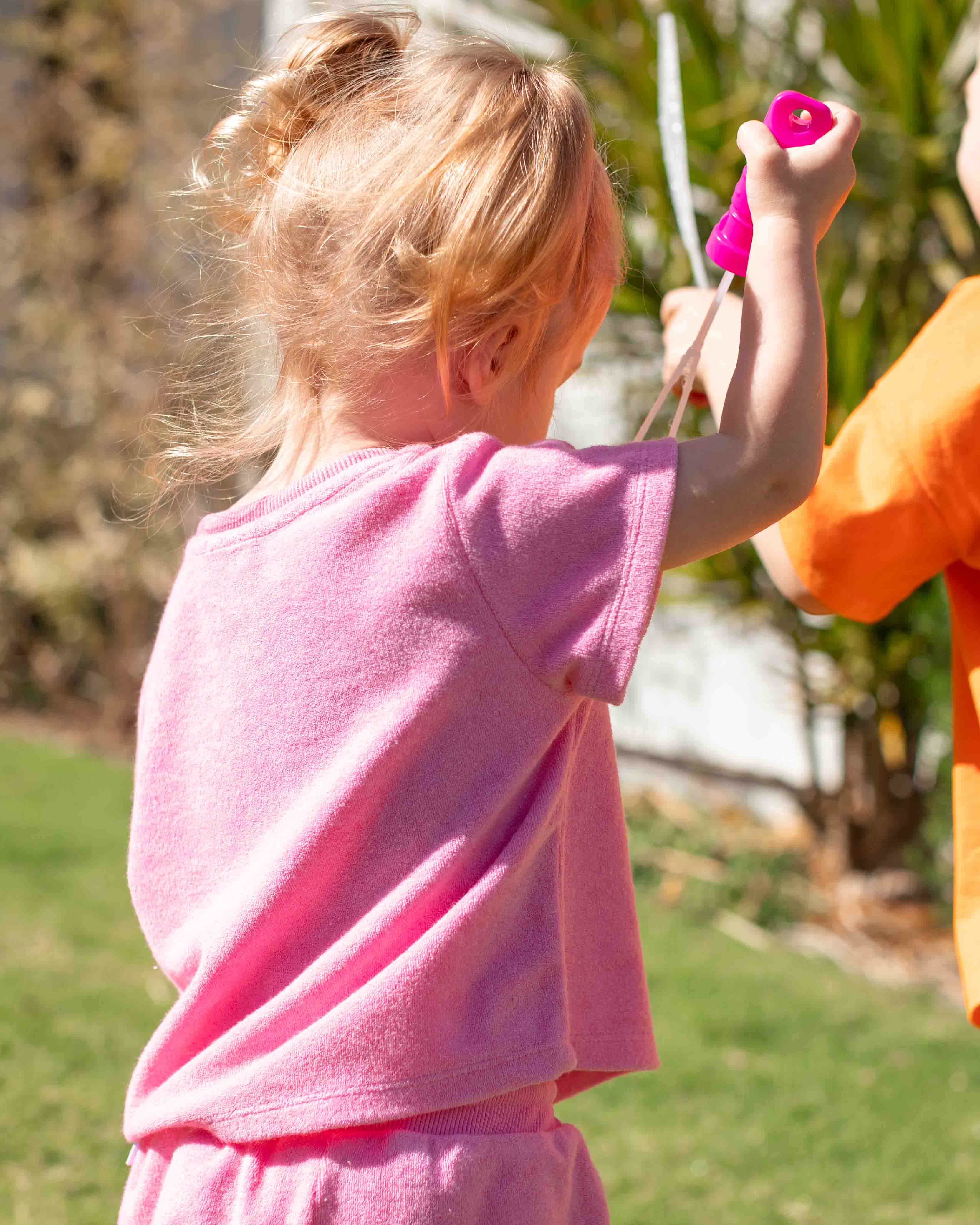 Young girl in a bright pink terry towelling t-shirt and matching shorts