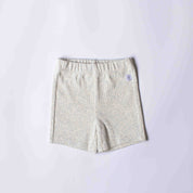 A pair of light beige heathered shorts with an elastic waistband, laid flat on a light gray background.