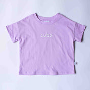 A light purple short-sleeve t-shirt with the word 'cubs' embroidered in white script across the chest, laid flat on a light gray background.