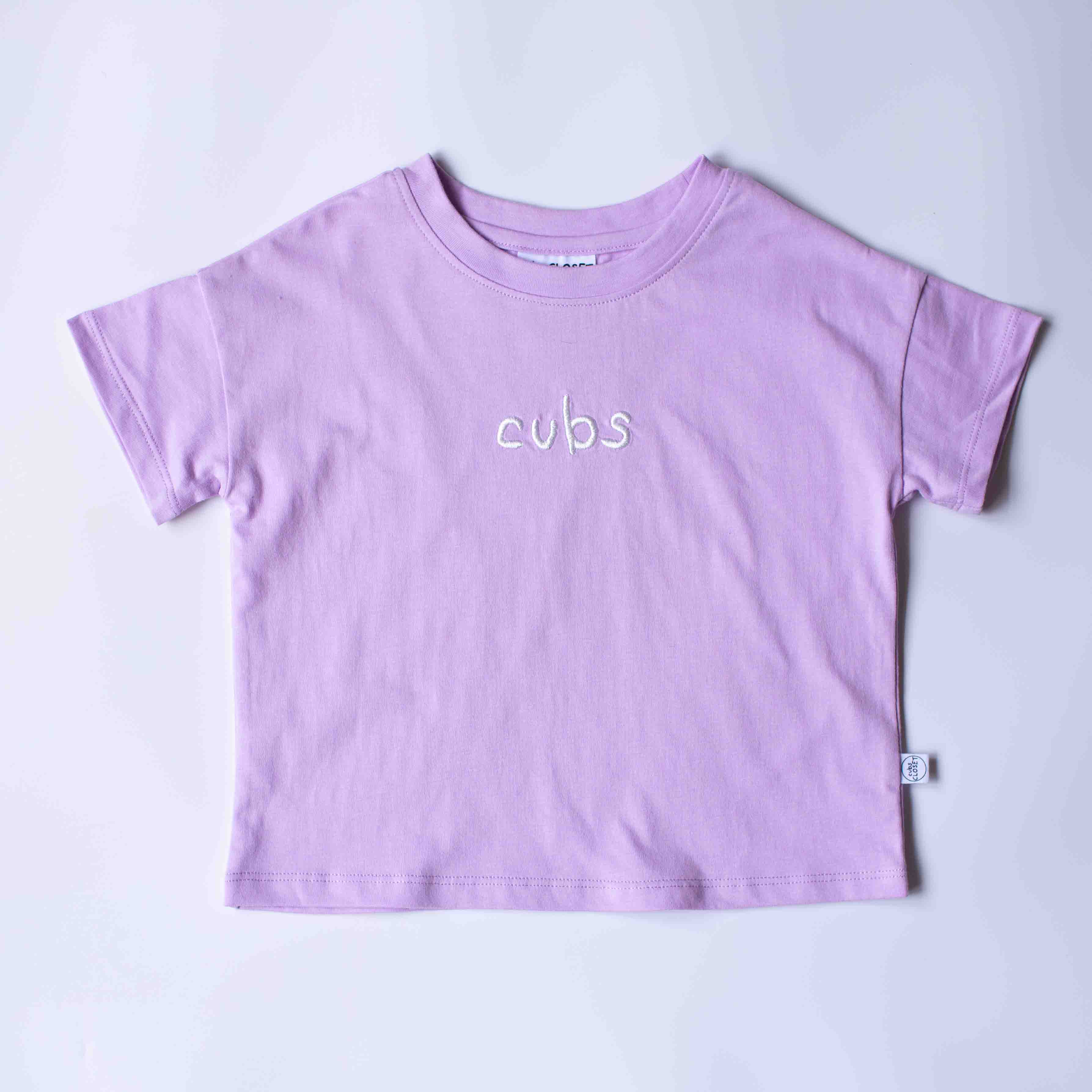 A light purple short-sleeve t-shirt with the word 'cubs' embroidered in white script across the chest, laid flat on a light gray background.