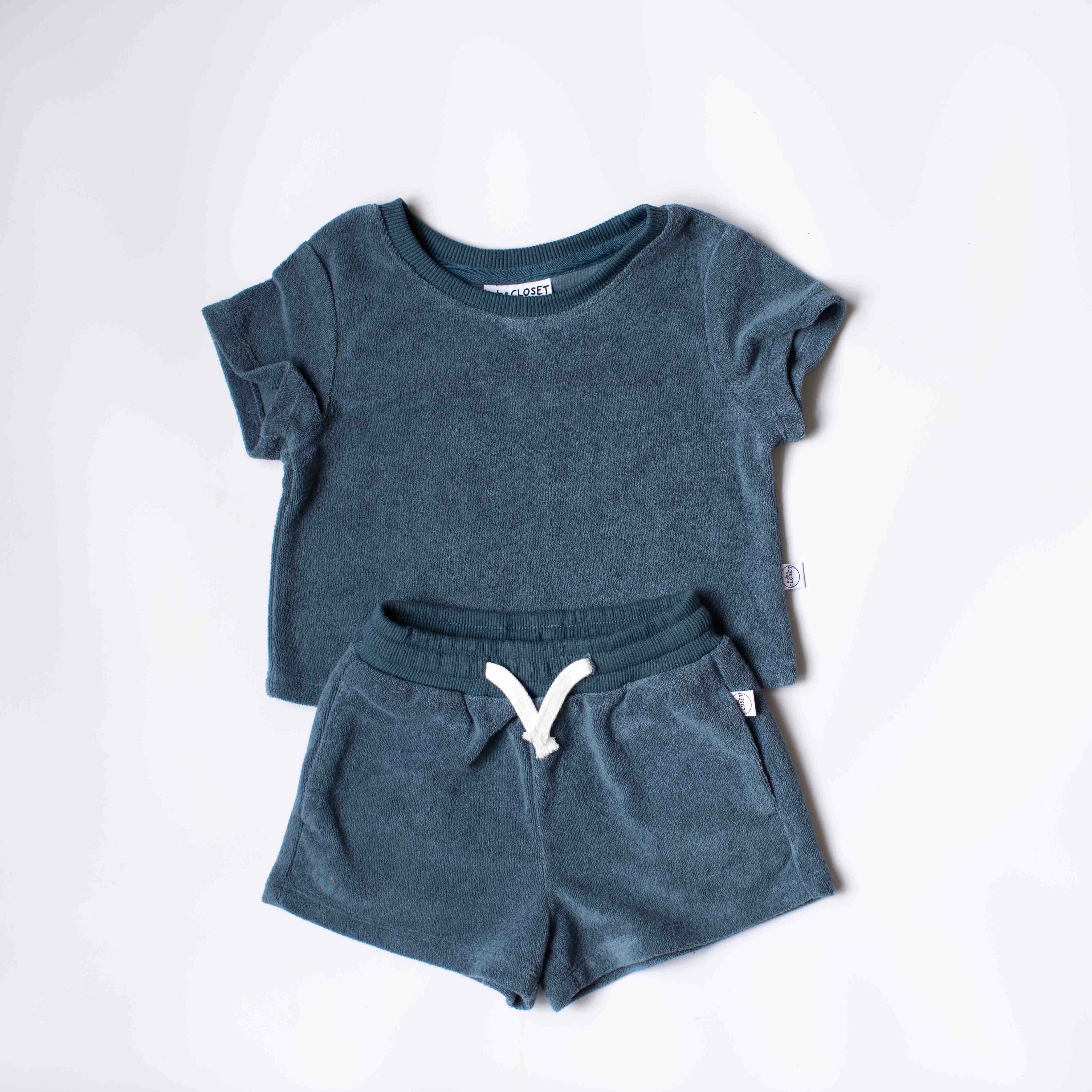 A toddler's two-piece lounge set consisting of a short-sleeve crewneck t-shirt and matching drawstring shorts in a heathered slate blue color, laid flat on a white background.