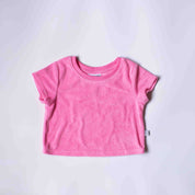 A pink short-sleeve baby t-shirt laid flat on a light gray background.