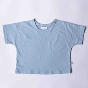 A light blue short-sleeve crop top t-shirt laid flat on a light gray background. The shirt features a relaxed fit, short wide sleeves, and a crew neck with a visible 'miki CLOSET' brand label.